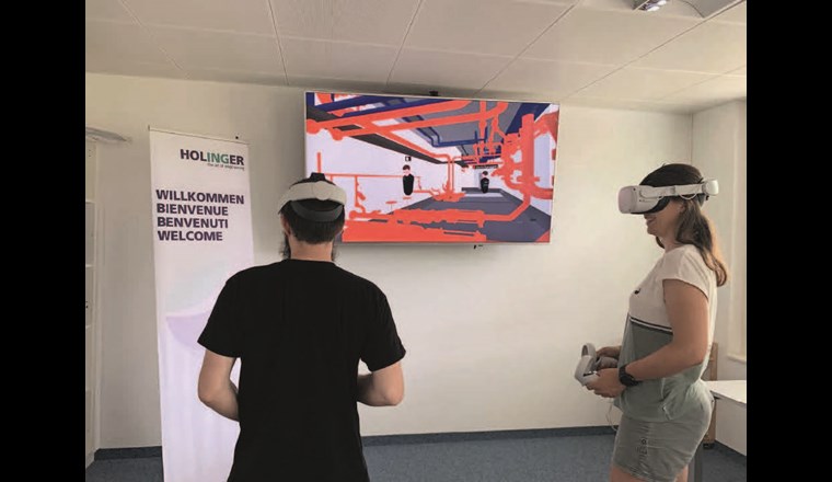 Fig. 5 Projekt-Meeting mit VR-Brille, die beiden Controller dienen der Navigation im Modell, auf einem zusätzlichen Bildschirm wird das Sichtfeld der VR-Brille für die anderen Teilnehmer gestreamt.