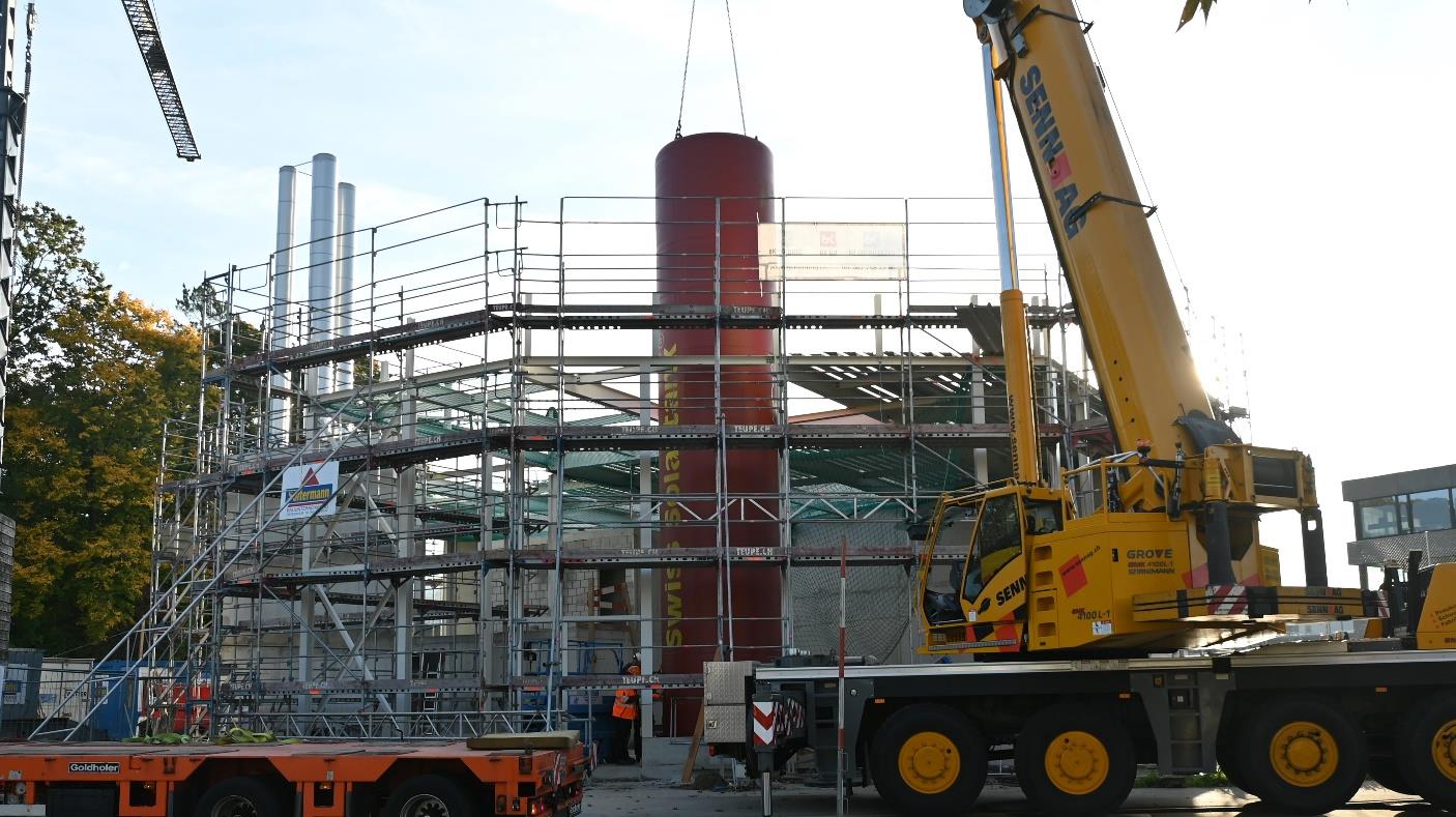 Der riesige Wasserspeicher wurde mit einem Kran in die Fernwärmezentrale gehoben und anschliessend installiert. (© StWZ)
