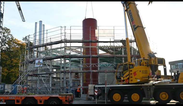 Der riesige Wasserspeicher wurde mit einem Kran in die Fernwärmezentrale gehoben und anschliessend installiert. (© StWZ)