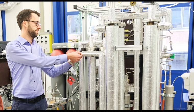 Hightech: Die Erkenntnisse aus dem neuen Reaktorkonzept dienen als Basis für den Bau von Grossanlagen: Florian Kiefer, Projektverantwortlicher für die sorptionsverstärkte Methanisierung, neben der Versuchsanlage. (Bild: ©Empa)