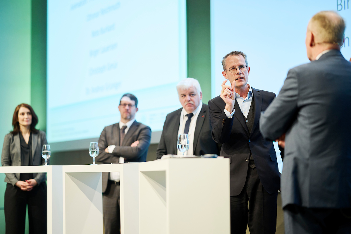 An der Podiumsdiskussion gingen die Teilnehmenden unter anderem der Frage nach, ob Fernwärme in Zukunft zur Grundversorgung zählen soll, so wie Wasser oder Strom. V.l.: Andrea Grüniger, Reto Burkard, Othmar Reichmuth, Matthias Sulzer von der Empa, der als Moderator agierte, und Birger Lauersen. (Quelle: Thermische Netze Schweiz/© Manu Friederich)