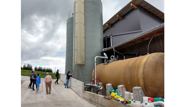 Die 1995 erbaute Biogasanlage in Süderen (Kanton BE). Bei der kürzlich erfolgten Erneuerung der Anlage wurden zwei Tanks (Bildhintergrund) errichtet, in denen die Hydrolyse – der erste der vier Prozessschritte der Vergärung – gesondert stattfindet. Mit dieser geänderten Prozessführung konnte der Durchsatz der Biogasanlage deutlich erhöht werden, wie Wolfgang Merkle (ZHAW) an der Bioenergieforschungs-Tagung in Bern berichtete. (Bild: ©ZHAW)