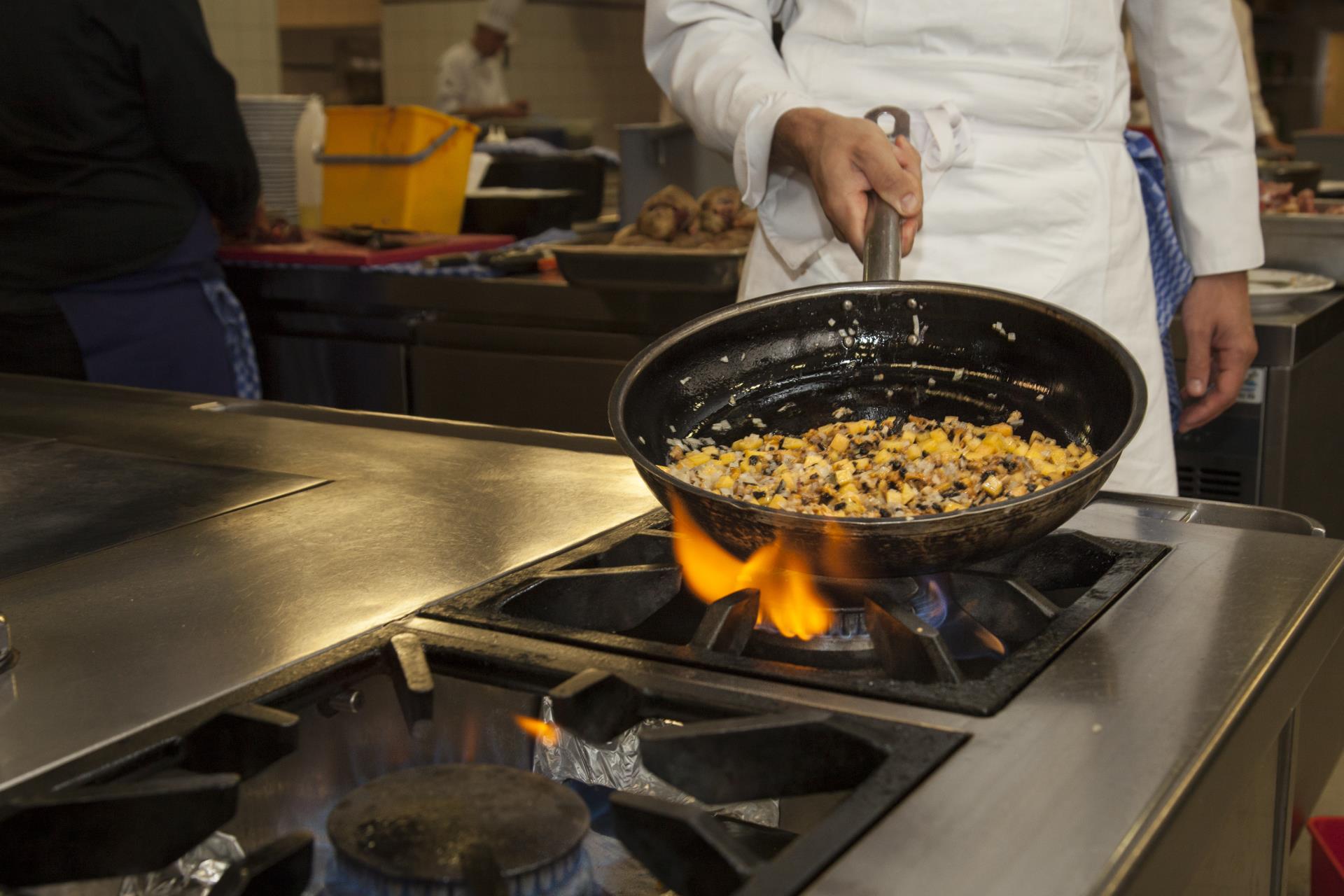 Der Koch bei der Zubereitung einer Gemüsepfanne mit frischen Produkten aus der Region
