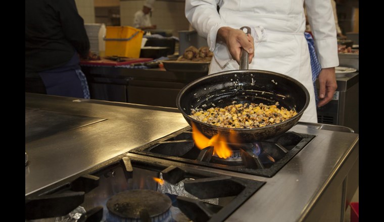 Der Koch bei der Zubereitung einer Gemüsepfanne mit frischen Produkten aus der Region