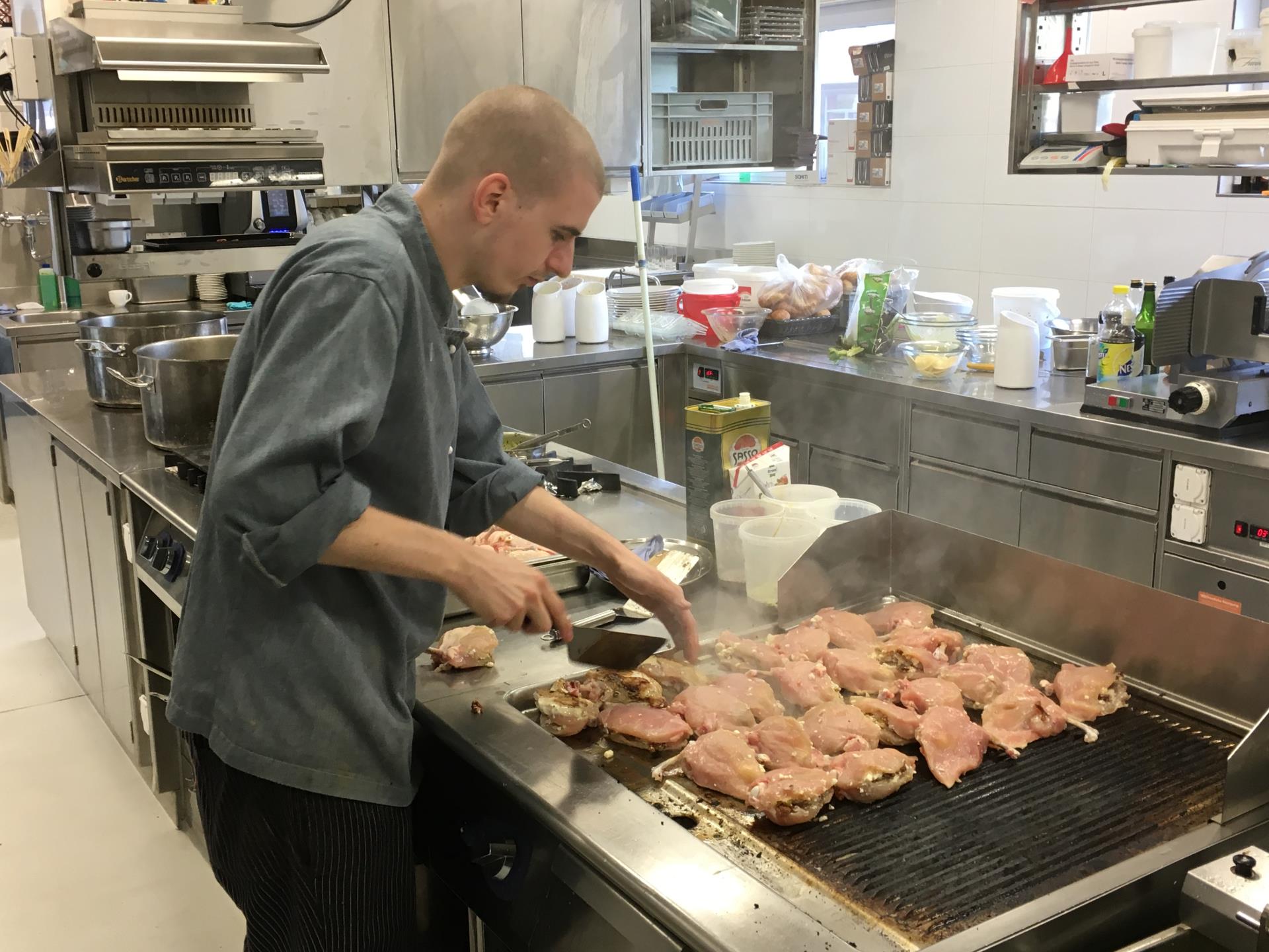 Der Koch beim Anbraten der edlen Fleischspezialitäten auf dem Gasgrill