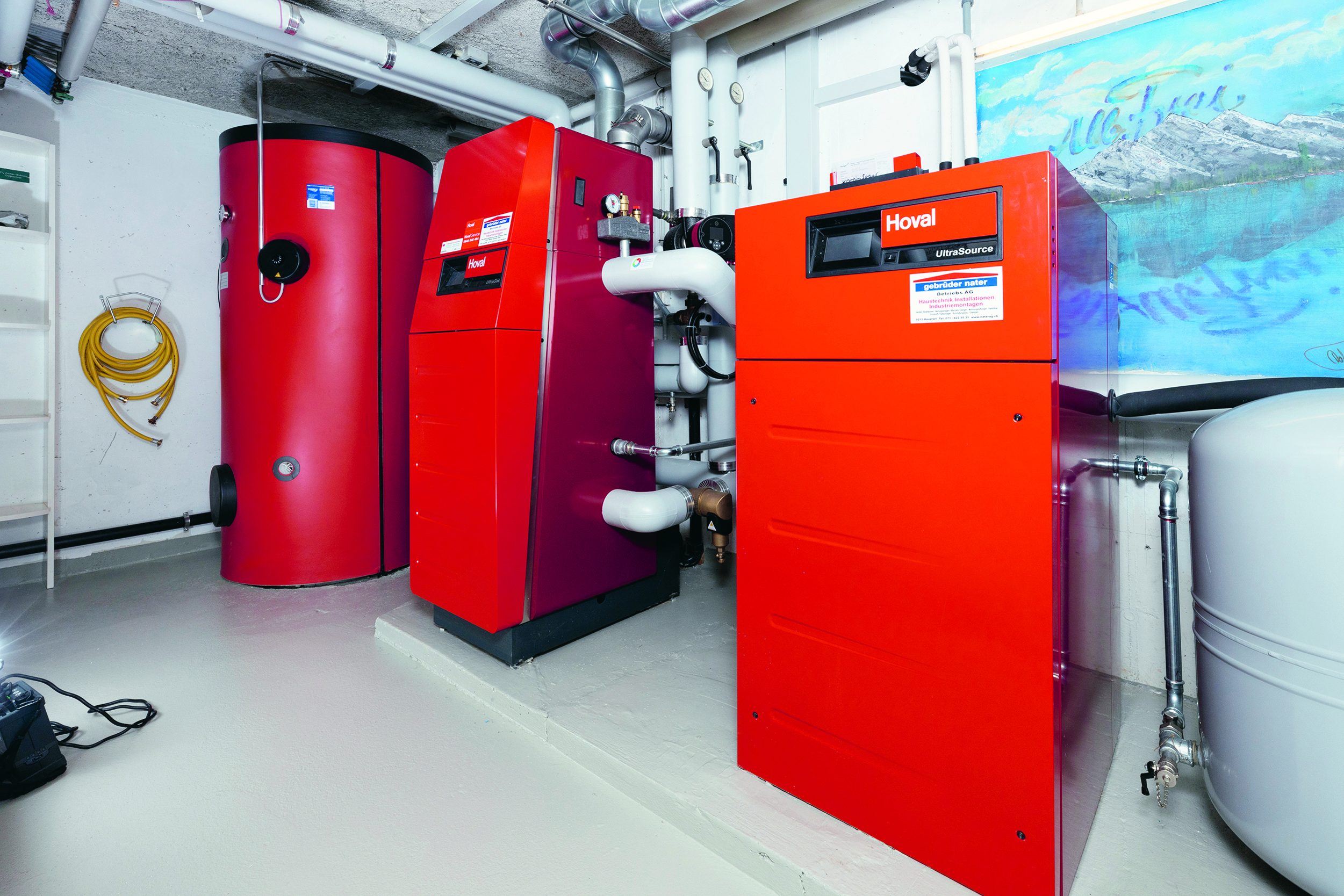 Das hybride Heizsystem mit der Wärmepumpe rechts, der Gasheizung in der Mitte und dem Speicher links. (Quelle: Hoval AG)