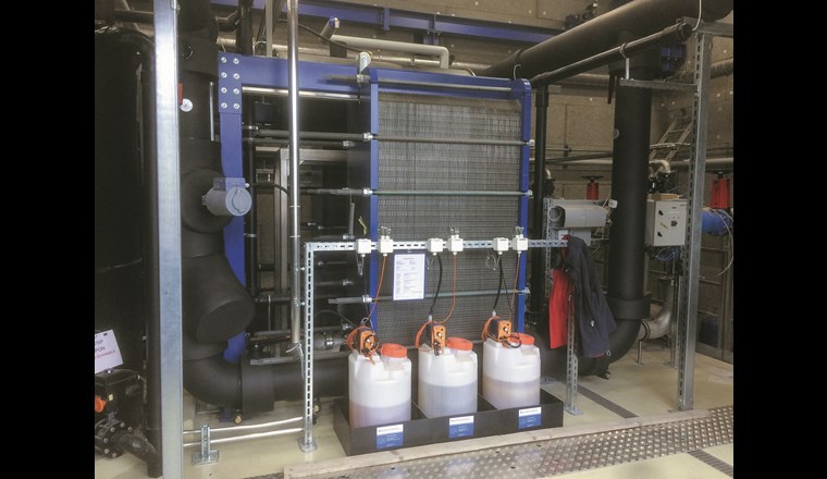 Plattenwärmetauscher und Reinigungsanlage. Im Vordergrund sind die Reinigungs- und Desinfektionsflüssigkeiten für die automatische Spülung der Wärmetauscher zu sehen.