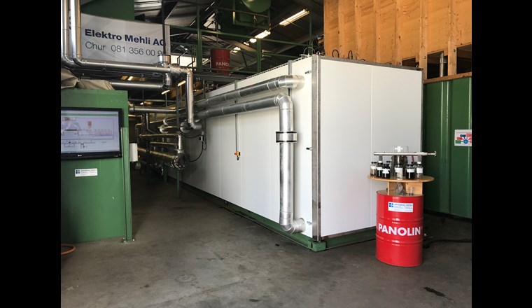 Über das isolierte vertikale Rohr im Vordergrund gelangt der auf 200 °C erhitzte und auf 20 bar komprimierte Klärschlamm in den HTC-Reaktor (weisser Container). Dort verwandelt sich der Klärschlamm in einem nur vier Stunden dauernden Prozess in Kohleschlamm, aus dessen Feststoffen anschliessend durch Pressung HTC-Kohle gewonnen wird.  (©BFE-Schlussbericht)