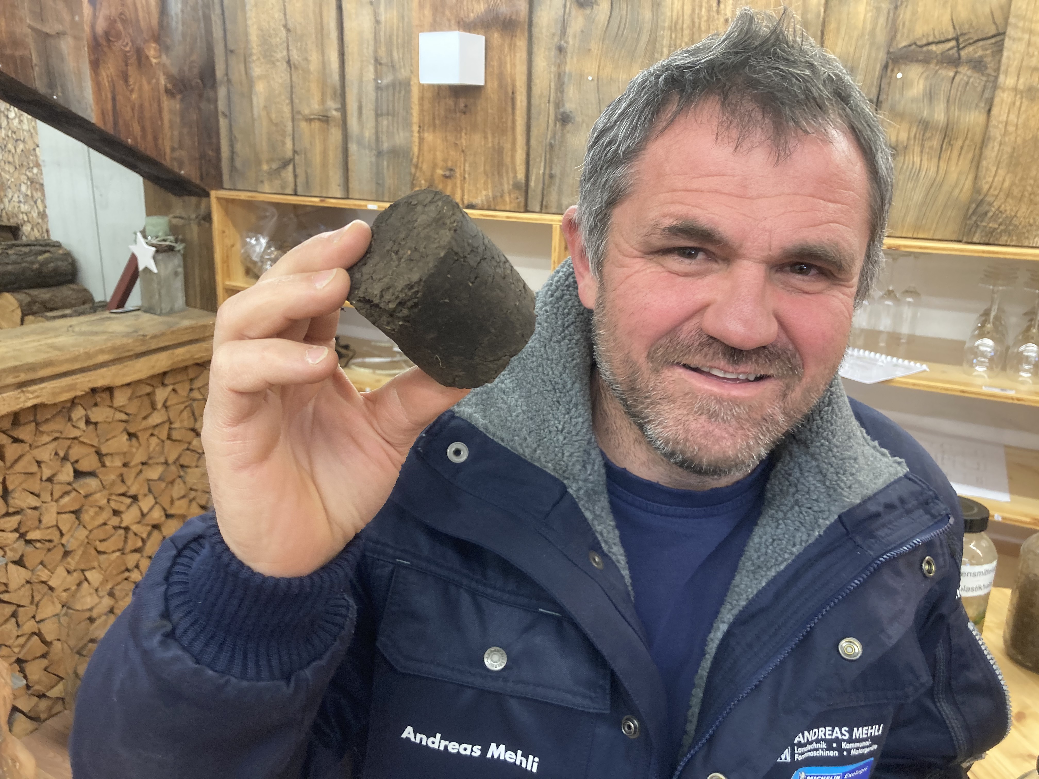 Andreas Mehli zeigt ein Stück HTC-Kohle. Das Produkt der hydrothermalen Karbonisierung wird oft auch als Biokohle bezeichnet, was allerdings missverständlich ist, da auch fossile Kohle «biologischen» Ursprungs ist. HTC-Kohle kann für die Energieerzeugung genutzt werden, sie ist aber auch als Bodenverbesserer, Dünger oder als Werkstoff für die Batterieherstellung im Gespräch. (©B. Vogel)